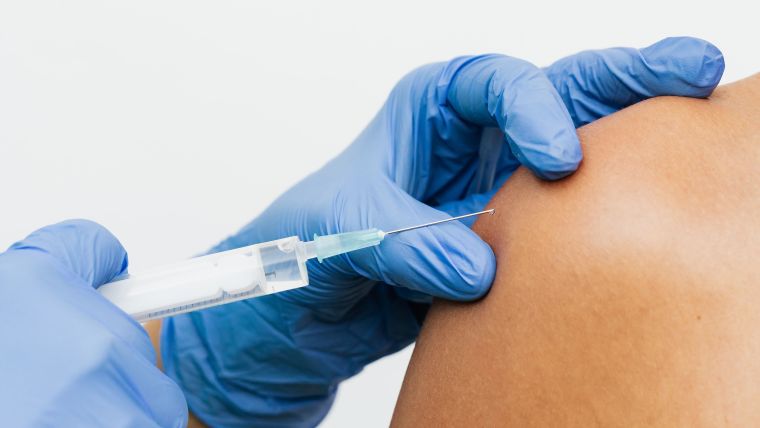 A vaccine being injected into a woman's upper arm