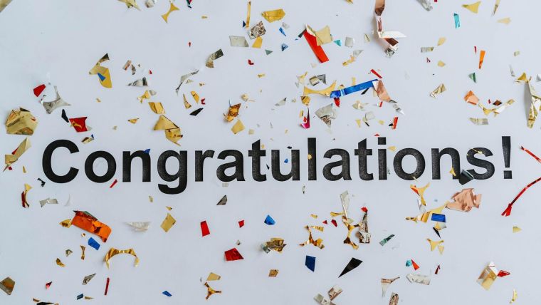 Congratulations text on white surface with confetti